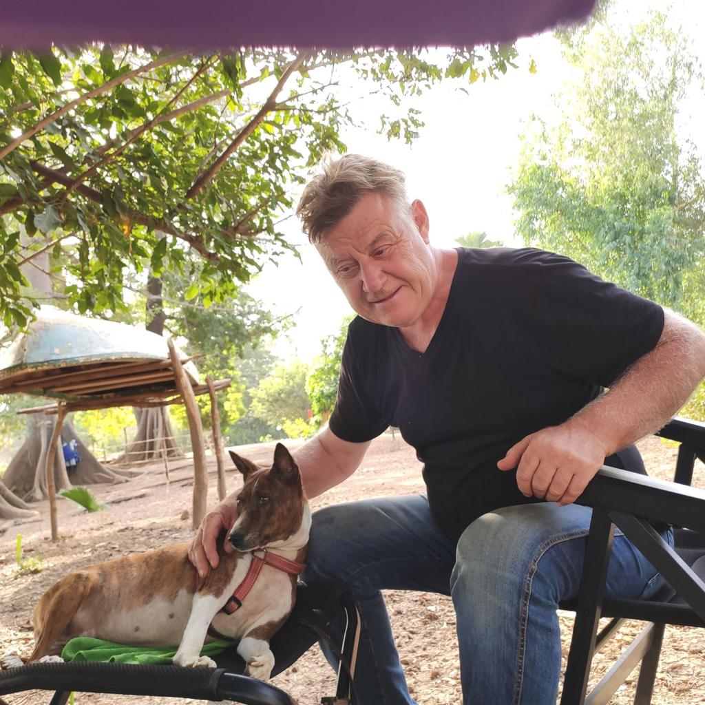Mann hält braun-weißen Hund im Freien